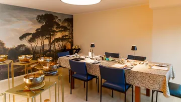 Dining room with paintings and blue chairs.