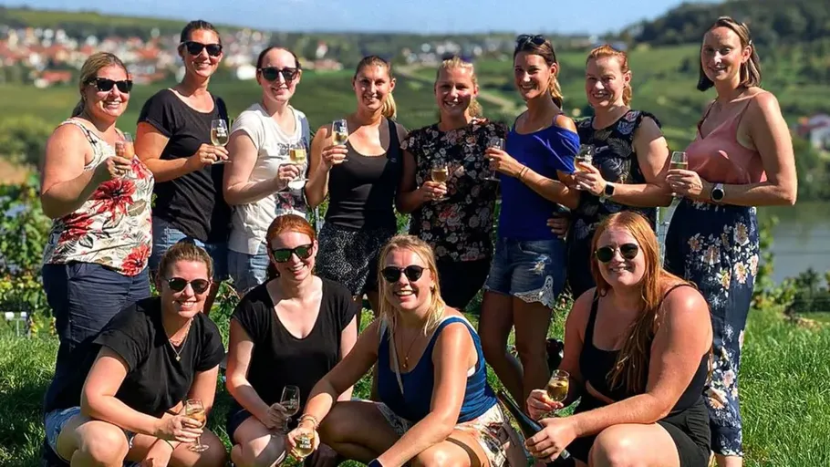 Gruppe Frauen stoßen in einem Weinberg an.