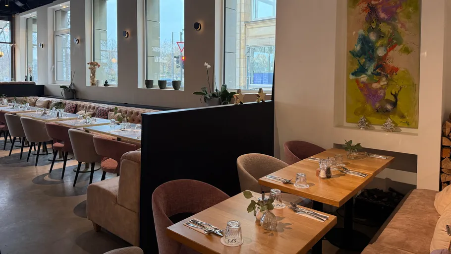 Modern restaurant with wooden tables and chairs.