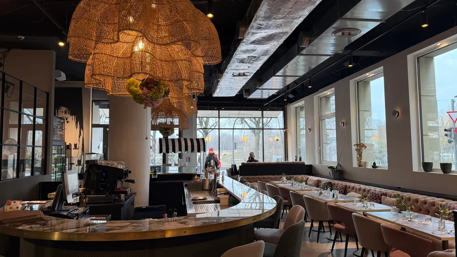 Elegant restaurant with curved bar and hanging lights.