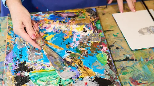 Hand painting on colorful canvas with palette knife.