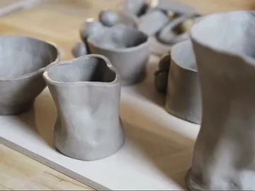 Töpferwaren stehen auf einem Tisch aus Holz.