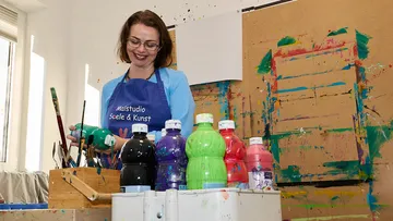 Frau malt im Kunststudio mit bunten Farben.
