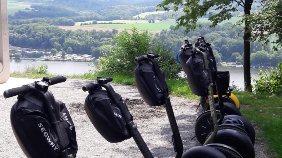 Segways parked on a lakeside path.