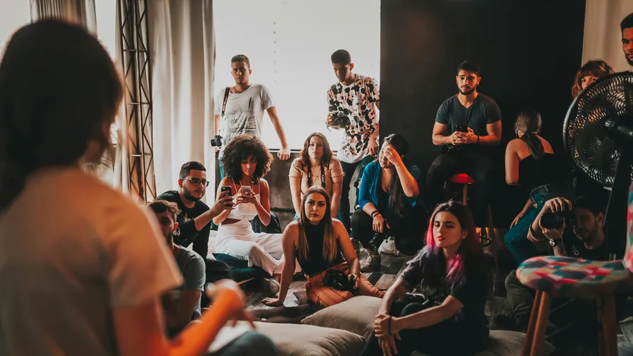 Group of people attentively listening in a room.
