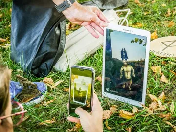 Tablet shows digital figure in a green environment.