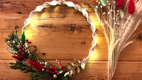 Kranz mit Lichtern auf Holztisch.