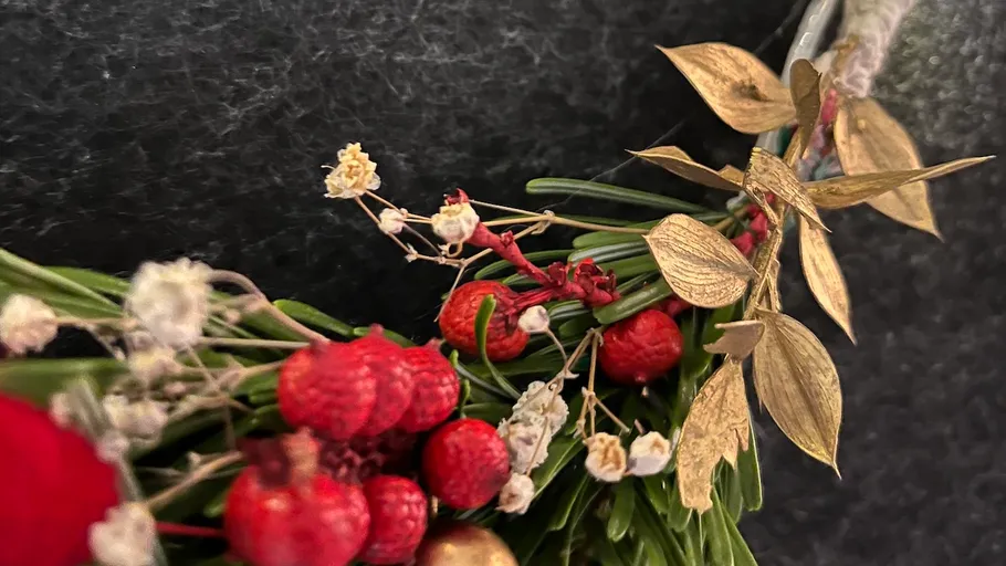 Dekorativer Kranz mit Beeren und Blättern.