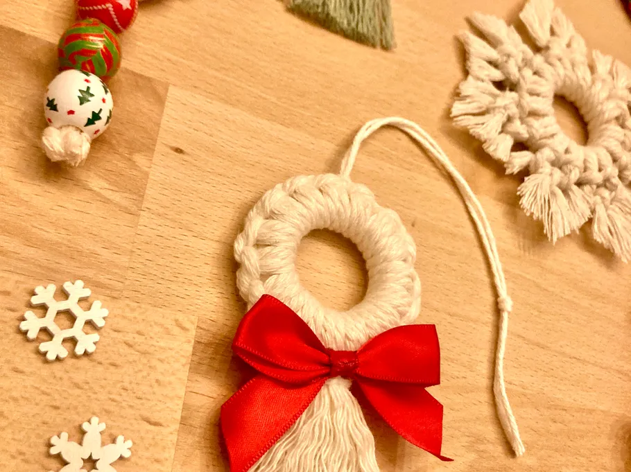 Macrame ornaments with bows on wooden surface.