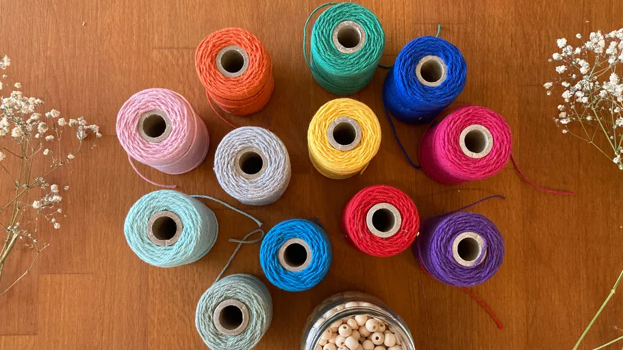 Colorful thread spools and beads on a table.
