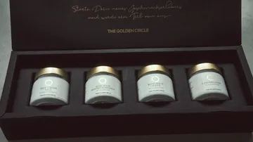 Four jars of condiments in a box.