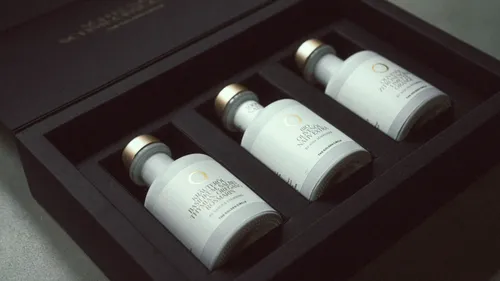 Drei Olivenölflaschen in schwarzer Box.