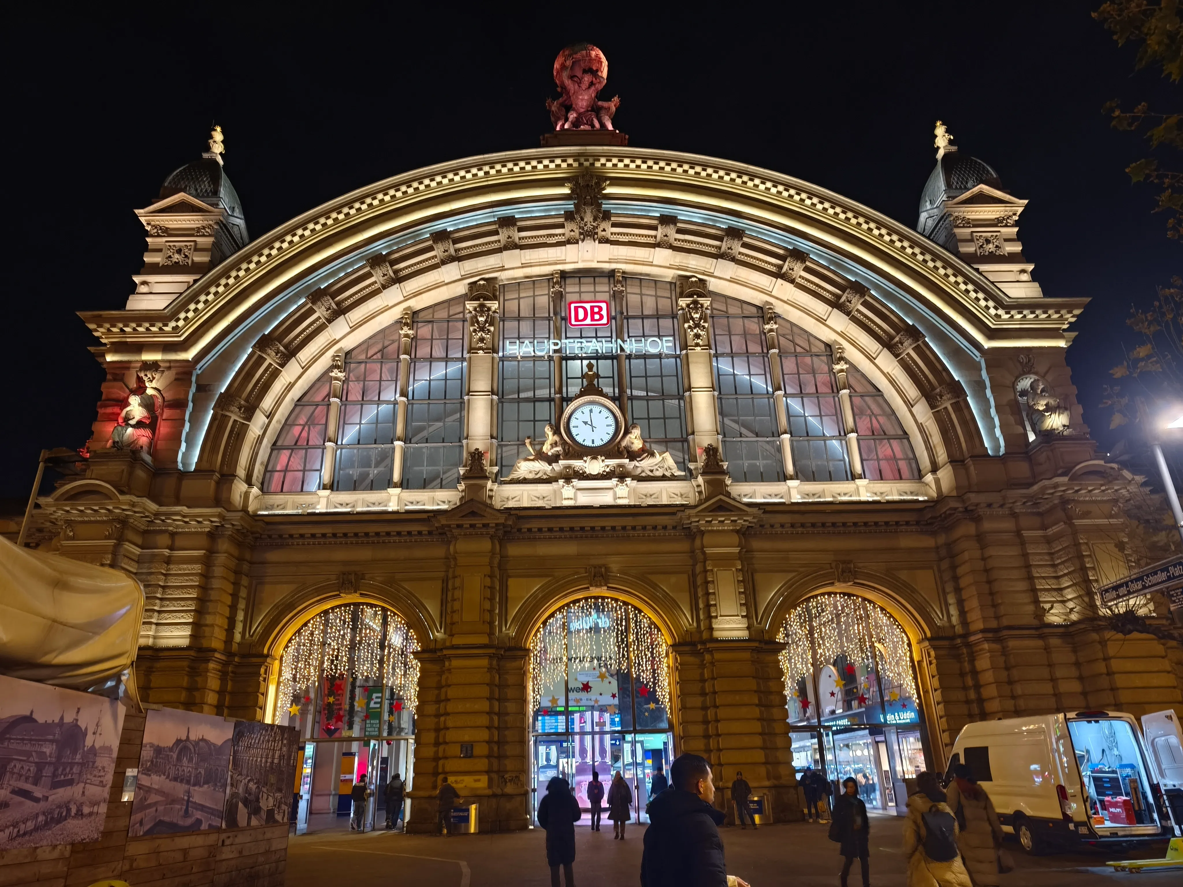 Beleuchteter Bahnhofseingang bei Nacht.