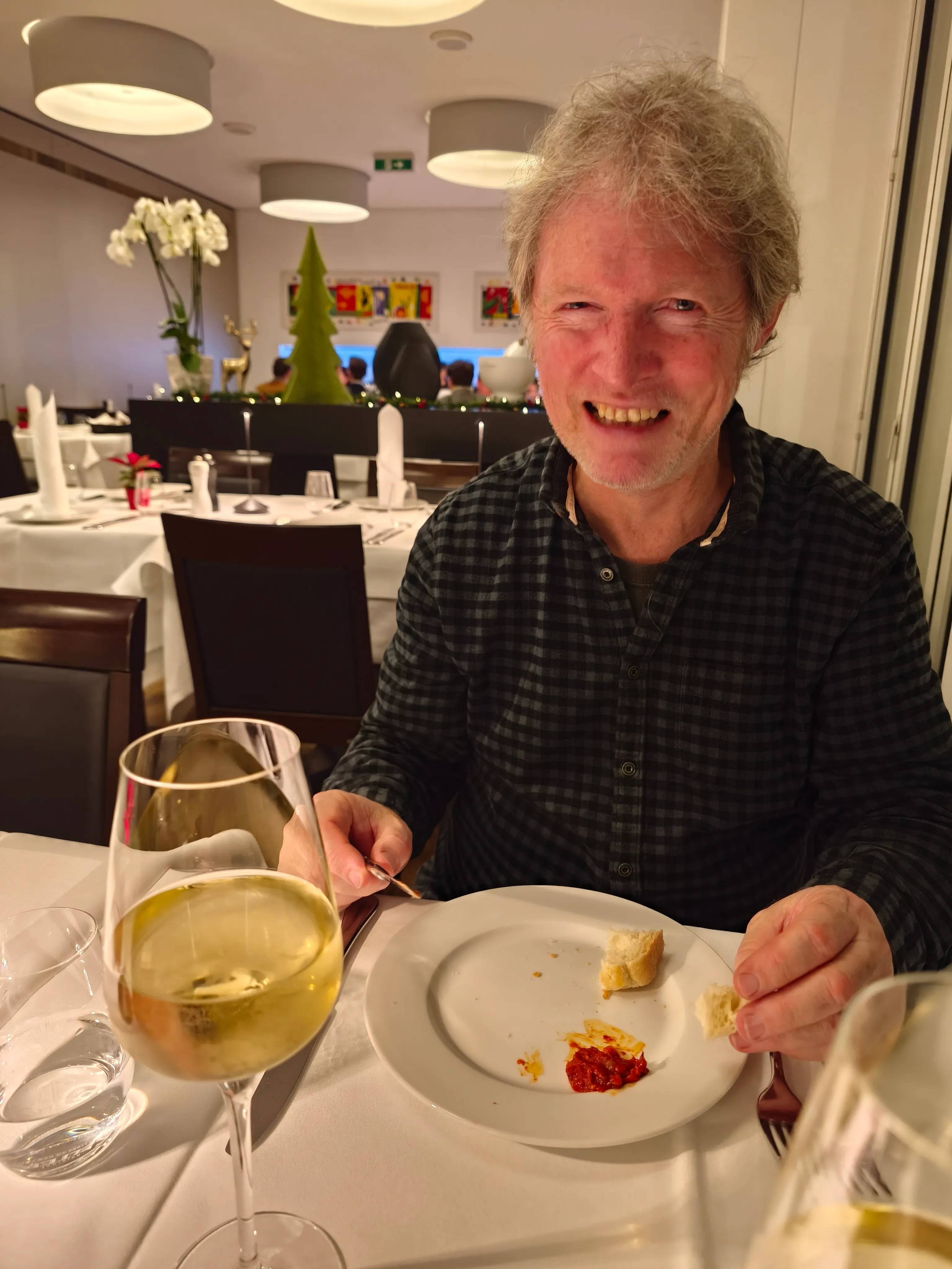 Person lächelt, speist mit Wein im Restaurant.