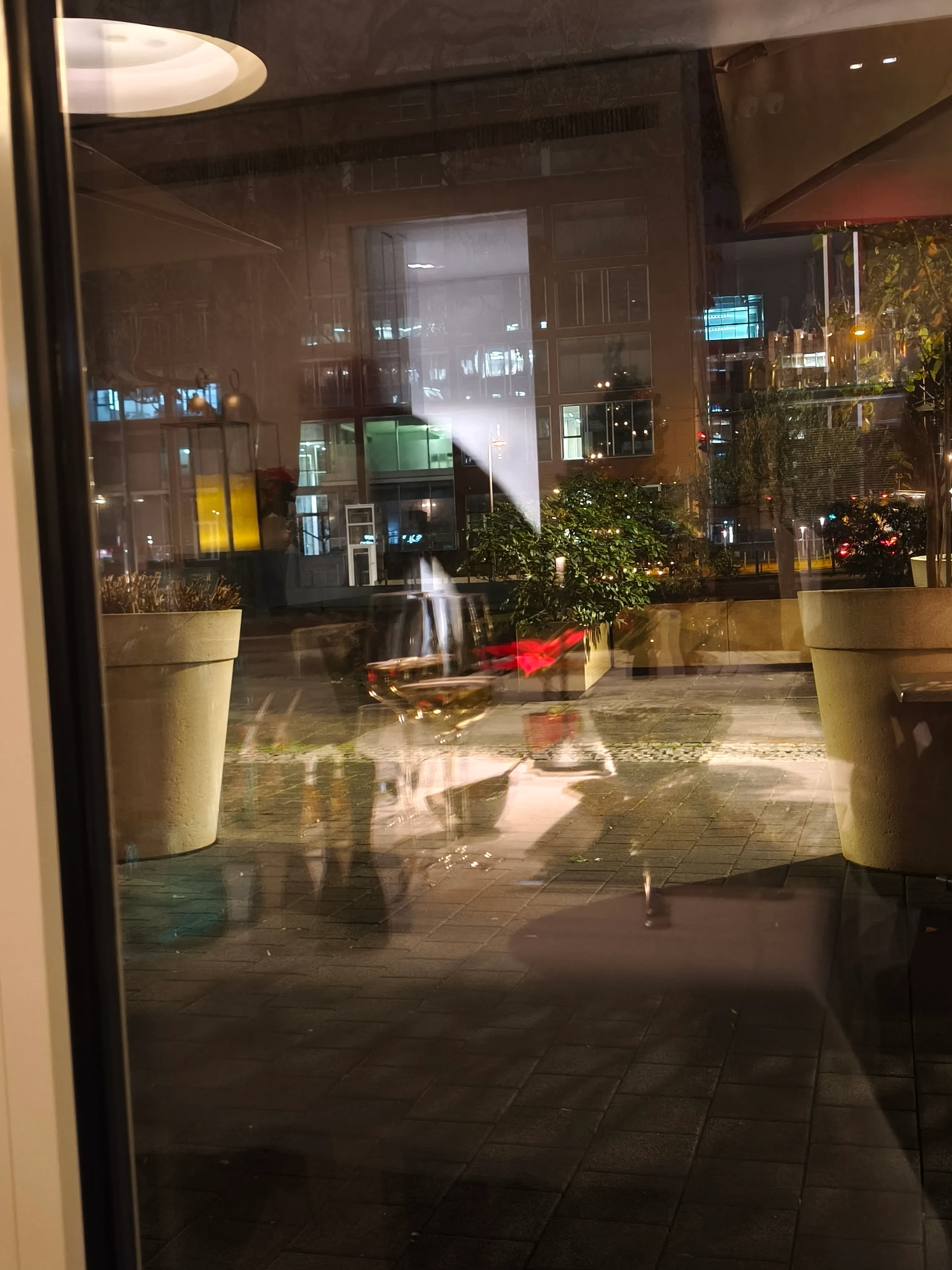 Stadtstraßenreflexion durch Fenster bei Nacht gesehen.