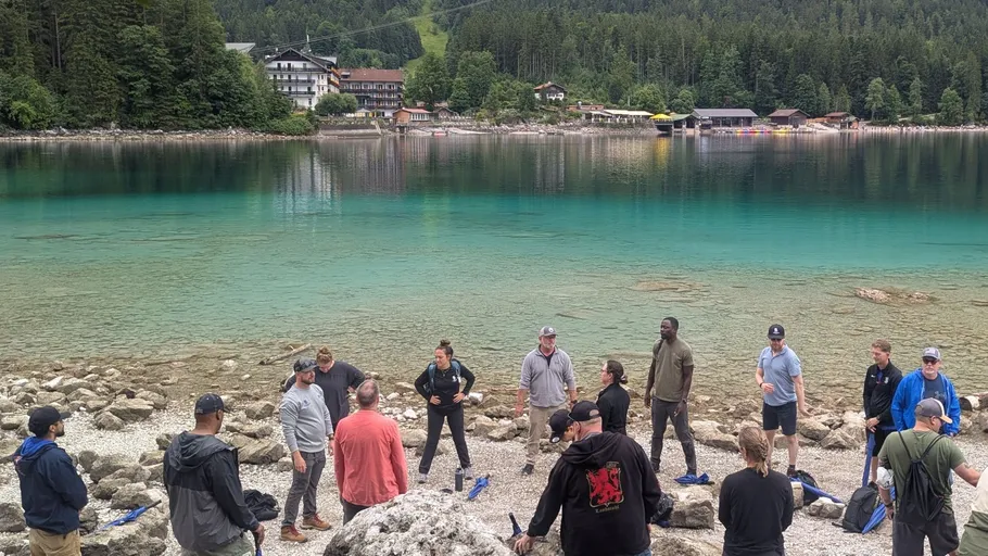 Group standing near a scenic lake.