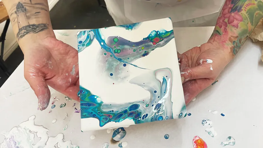 Person holding colorful paint artwork.