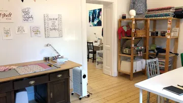 Cozy sewing room with organized fabrics.