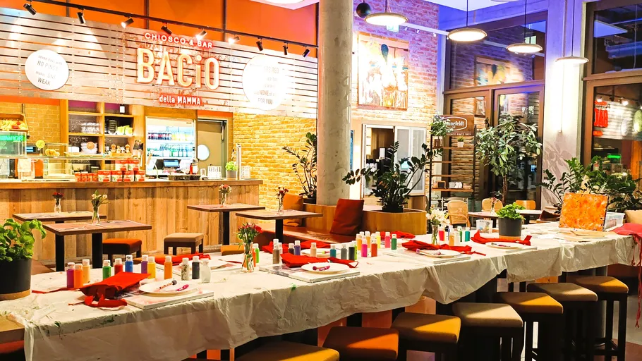 Long table with art supplies in a cafe.