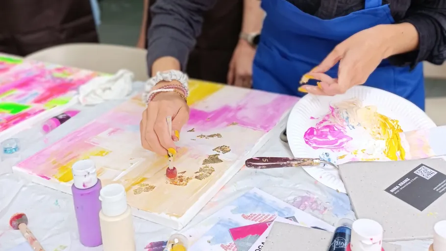 Person painting art with colorful paints.