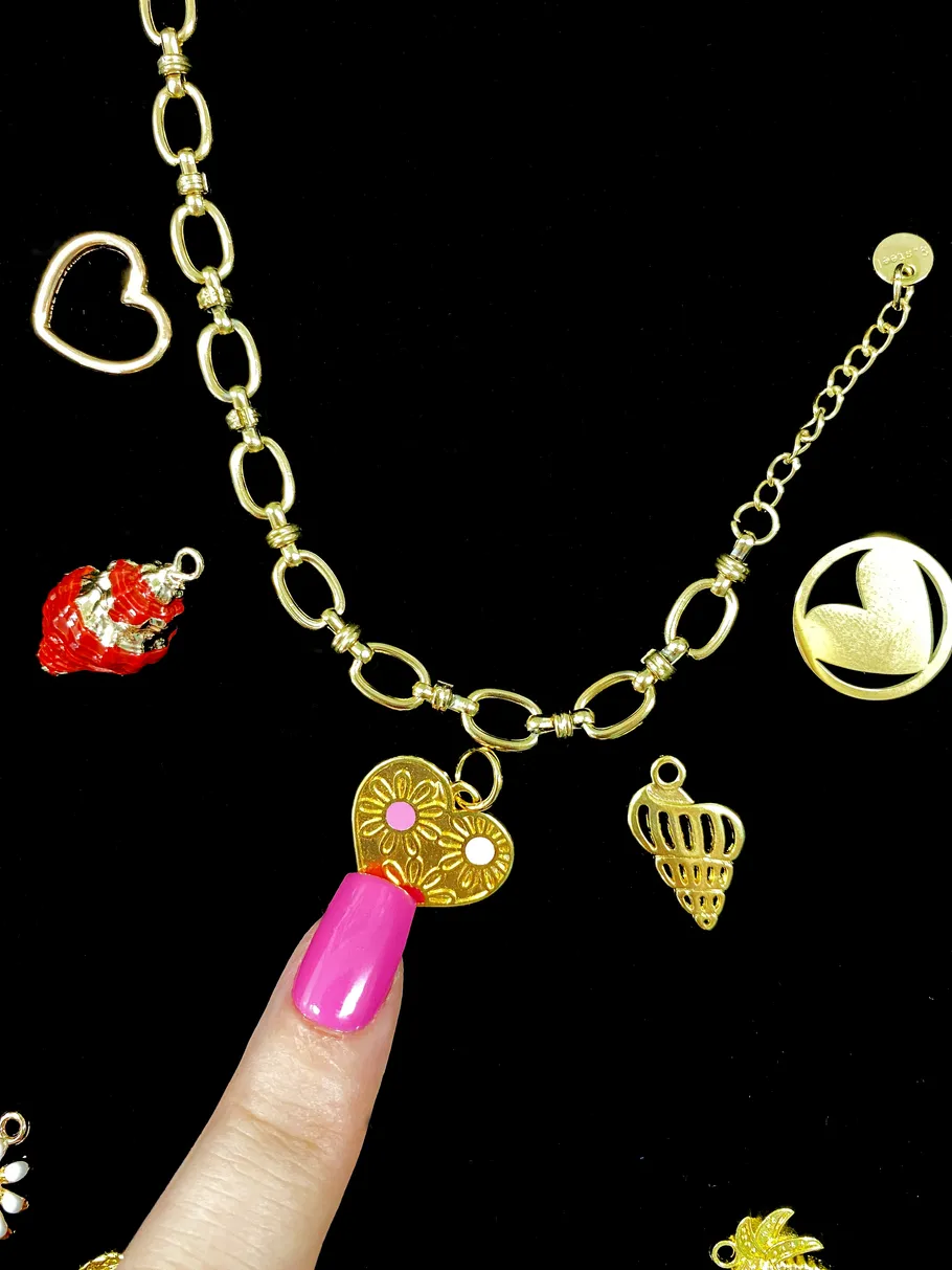 Gold charms and necklace on black background.