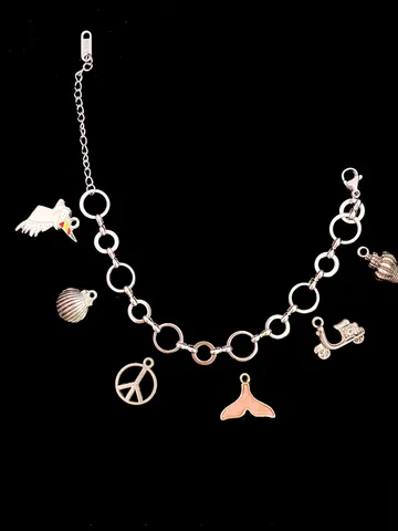 Charme-Armband mit verschiedenen Anhängern auf schwarzem Hintergrund.
