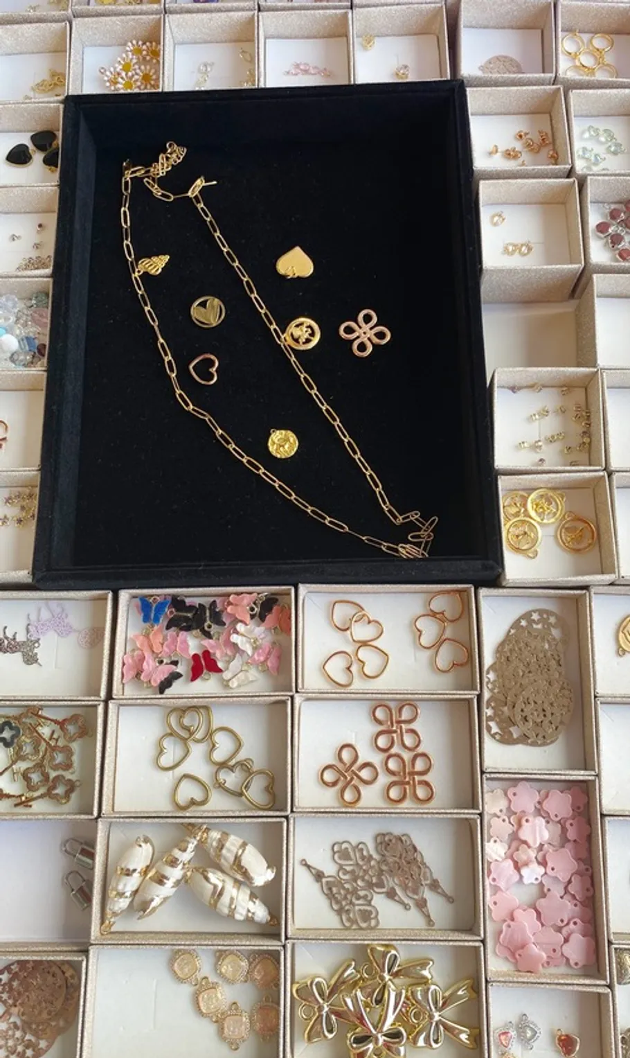 Necklaces and earrings arranged in small boxes.