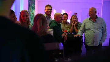 Group of people smiling at indoor party.