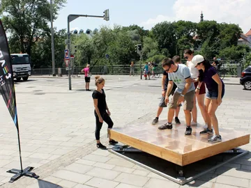 Five people stand on an outdoor platform.