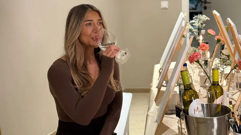 Woman drinking wine near decorated table.