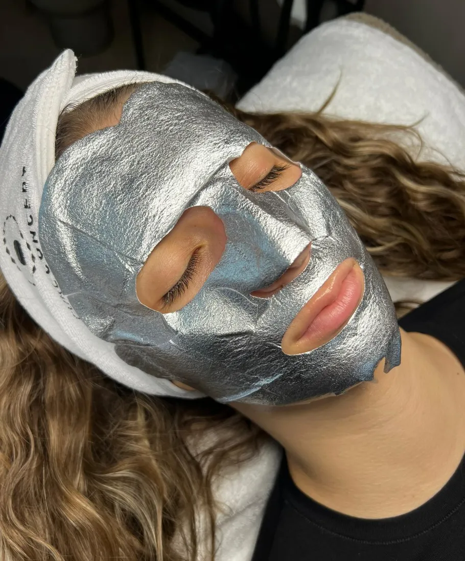 Person liegt mit einer silbernen Gesichtsmaske.