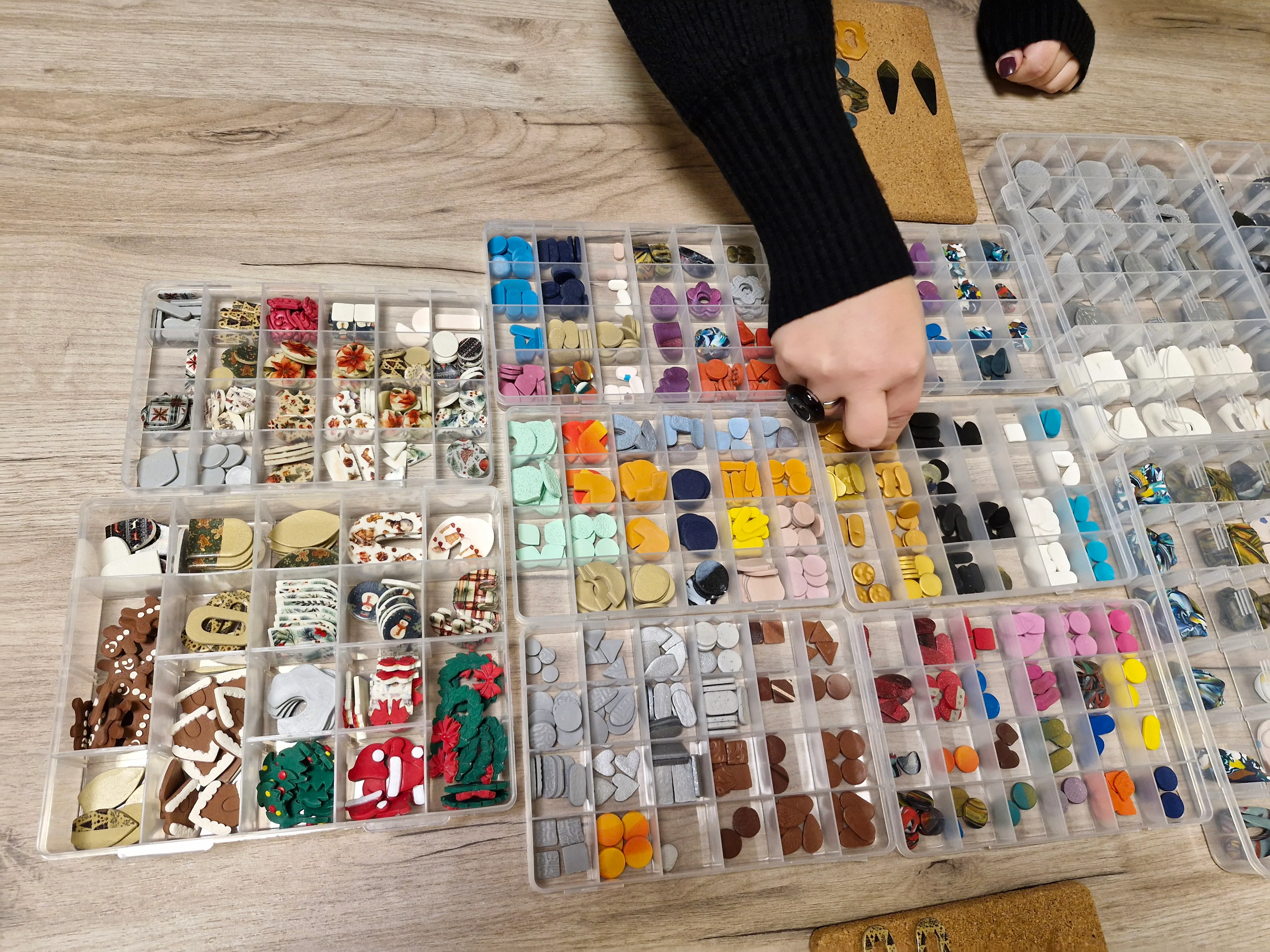 Person sorting colorful beads on table.