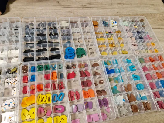 Verschiedene Bastelteile in Plastikbehältern sortiert.
