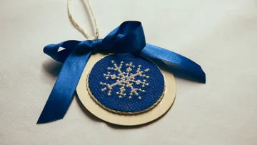 Blauer Anhänger mit Schneeflockenmotiv auf Stoff.