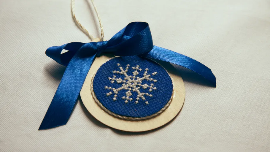 Blauer Anhänger mit Schneeflockenmotiv auf Stoff.