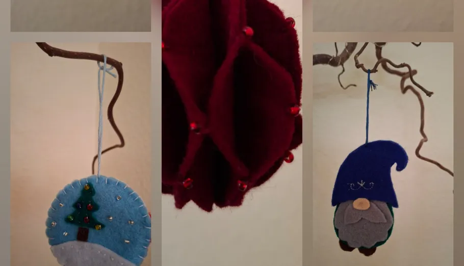 Felt ornaments hanging on branches indoors.