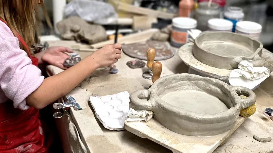 Person fertigt Keramik in einem Studio an.