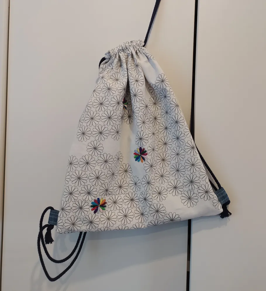 Drawstring bag with floral pattern hanging.