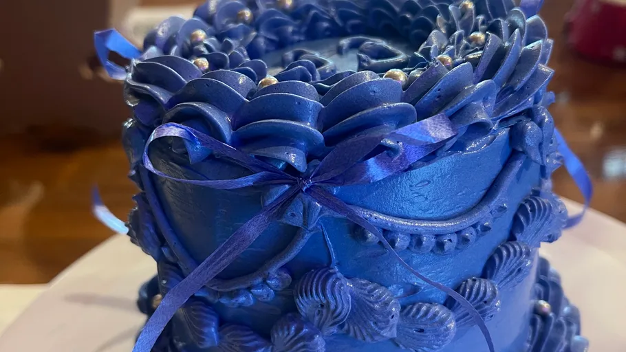 Blue cake with detailed frosting design.