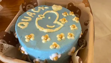 Blauer Kuchen mit Entendesign und Verzierungen.