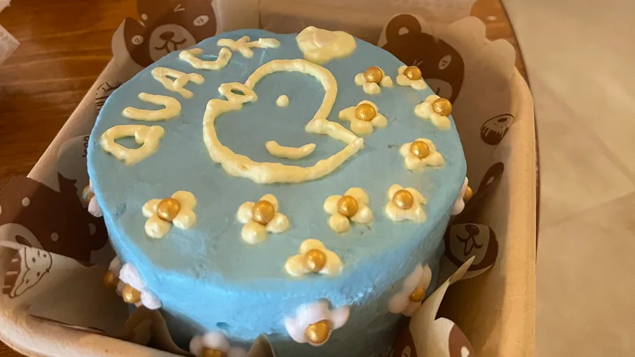 Blue cake with duck design and decorations.