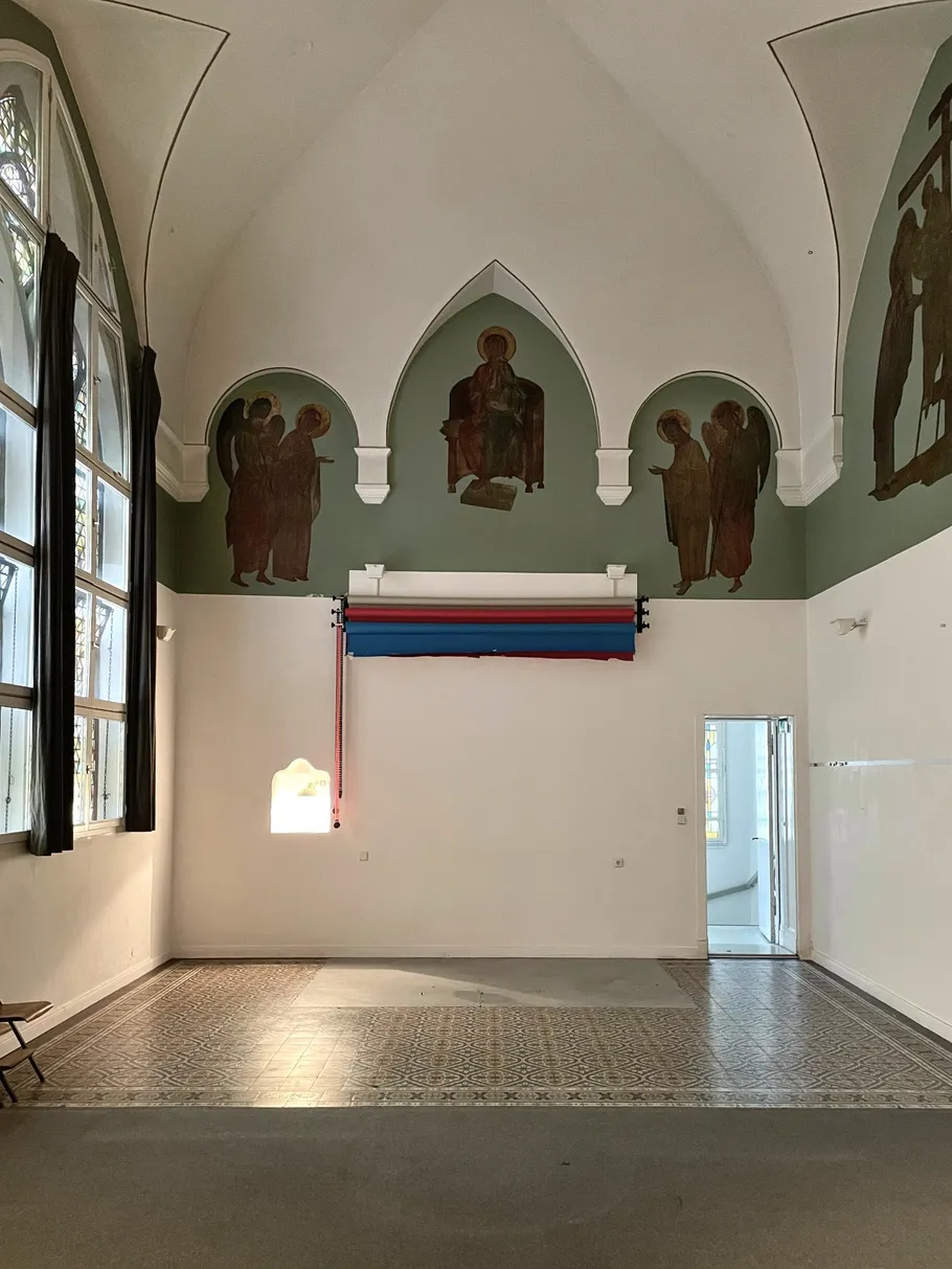 Empty room with arched ceiling, stained glass windows.