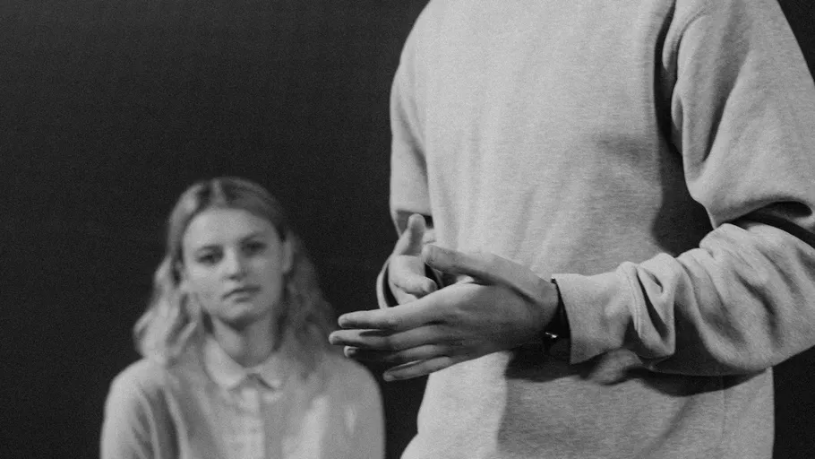 Person speaking, another person listens attentively.