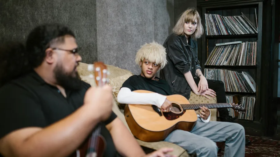 Three people playing guitars in a room.
