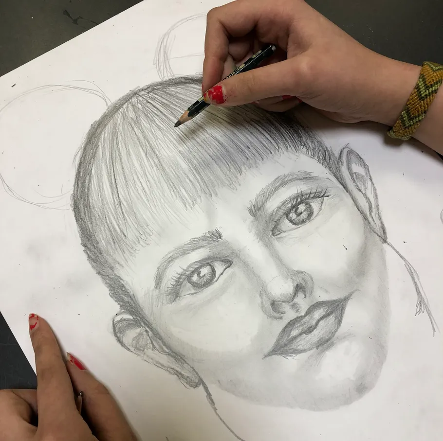 Hand zeichnet Porträt mit Bleistift auf Papier.