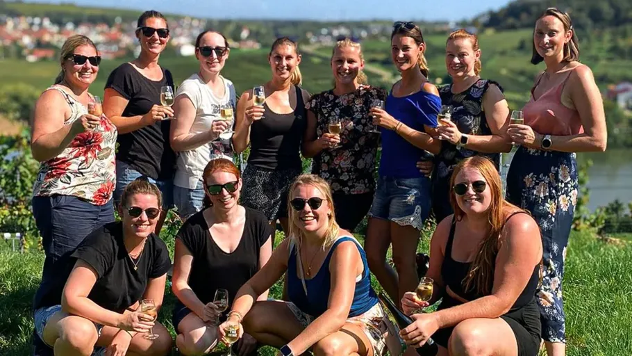 Gruppe von Frauen mit Weingläsern im Freien.