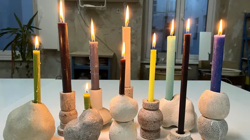 Bunte Kerzen in Tonhaltern, drinnen angezündet.