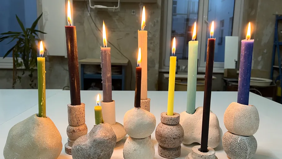 Bunte Kerzen in Tonhaltern, drinnen angezündet.
