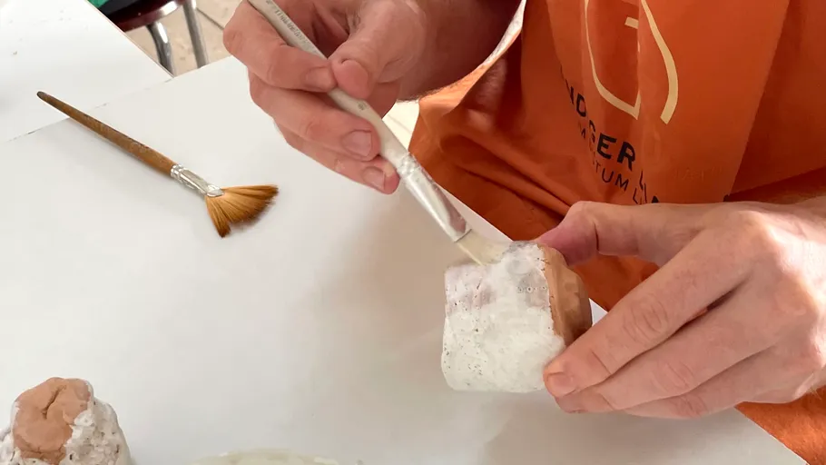 Hand painting a small plaster object.