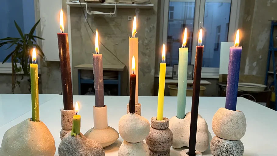 Colorful candles in unique holders on table.